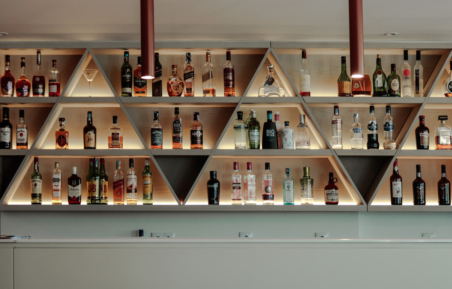 Hotel em Peniche, 2017 — garrafeira do bar em prateleiras triangulares de madeira